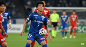 水戸ホーリーホックの津久井匠海選手が、中盤で顔を上げ、相手DFラインの裏へスルーパスを供給しようとしている瞬間の写真。