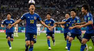 ヘディングでゴールを決め、チームメイトと最高の笑顔で喜びを分か-ち合っている日本人選手の写真。