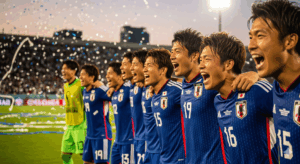 試合に勝利し、チーム全員で肩を組んで喜びを分か-ち合っている日本人選手たちの写真。